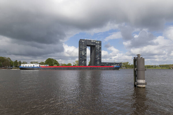 View of boat and surroundings by the sea in Groningen city in Holland. A large cargo ship is visible.