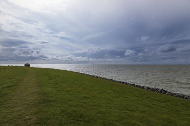 Hindeloopen Hollanda - Sahil manzarası ve deniz manzarası. Arka plan mavi bir gökyüzü ve dramatik bulutlardır..