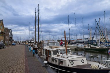 Hollanda 'daki URK limanı. Limanda, kayıklar demirli ve arka planda beyaz bulutlu mavi bir gökyüzü var..