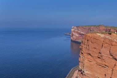 Deniz ve mavi gökyüzü ile güzel kayalık kıyı şeridi Almanya 'daki Helgoland Adası' nda uzun Anna.