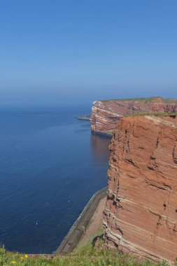 Deniz ve mavi gökyüzü ile güzel kayalık kıyı şeridi Almanya 'daki Helgoland Adası' nda uzun Anna.