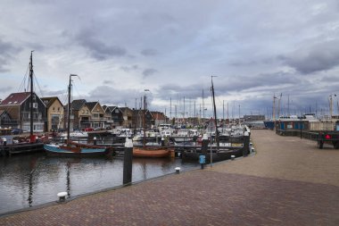 Gemilerin olduğu liman. Bulutlu mavi güneş arka planında.
