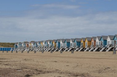 Hollanda 'nın Vlissingen kentindeki Kuzey Denizi' ndeki sahil ve kumlu plajlar. Sahildeki renkli evler bungalovlar gibi.
