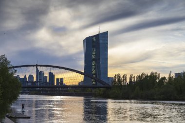 Gün batımında Frankfurt, Almanya 'da köprü ve binalara sahip bir nehir..