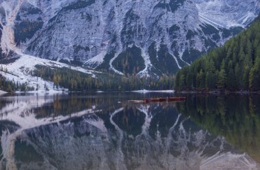 Güzel göl Brais, İtalyan Dolomitleri 'nde gökyüzünün yansıması ve yüzeydeki teknelerle