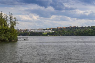 Brno Çek Cumhuriyeti 'ndeki Bystrc konutlarının manzarası. Brno barajındaki Sokolske iskelesini görebilirsin. Bir buharlı gemi su üzerinde yelken açar..