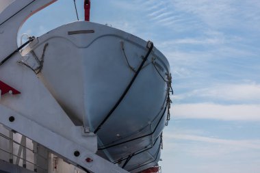 Denizden geçerken büyük bir gemide cankurtaran botu. Mavi gökyüzü.