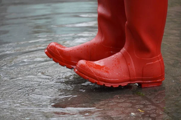 red rubber water boots generating a splash in a water