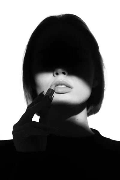 Модный рекламный портрет молодой красивой девушки с использованием помады. Черно-белый силуэт с эпическим светом . — стоковое фото