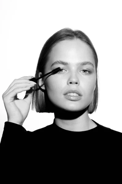 Episch promotioneel portret van een meisje met applicator en mascara borstel. Zwart-wit minimalistisch reclameconcept. — Stockfoto