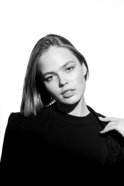 Güzel bir modelin şık siyah beyaz portresi. Beyaz arka planda izole edilmiş. Destansı ışık ve gölgeler.