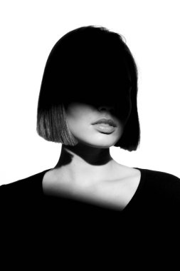 Moda bir güzellik portresi. Beyaz arka planda siyah siluet. Yüzünde ışık lekesi olan bir kız. 