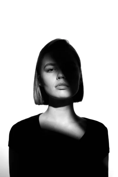 Modisches Schönheitsporträt. schwarze Silhouette auf weißem Hintergrund. Mädchen mit einem Lichtfleck im Gesicht. — Stockfoto