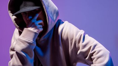 Neon ışıklı kapüşonlu Bboy 'un modern destansı portresi. Kaputun altında. Koyu surat. Gizemli ve havalı.