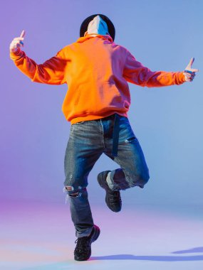 Stüdyoda çağdaş dans eden adam. Tarafsız gri arka plan. Akrobatik bboy dansçısı.