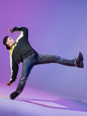 Kapüşonlu ve beysbol şapkalı break dans yapan genç adam. Dans okulu posteri. Uzayı kopyala Savaş yarışması duyurusu.