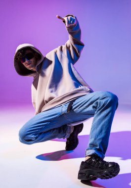 Kapüşonlu, kuaförlü, break dans yapan genç bir adam. Dans okulu posteri. Uzayı kopyala Savaş yarışması duyurusu.