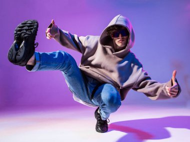 Kapüşonlu, kuaförlü, break dans yapan genç bir adam. Dans okulu posteri. Uzayı kopyala Savaş yarışması duyurusu.