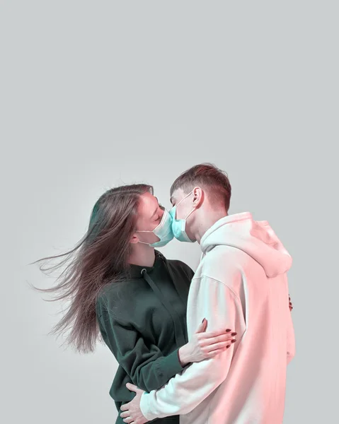 Erkek ve kız öpüşüyor. Yüzünde tıbbi koruyucu maske var. Virüs enfeksiyonu korkusu. Kopyalama alanı olan modern poster tasarımı.