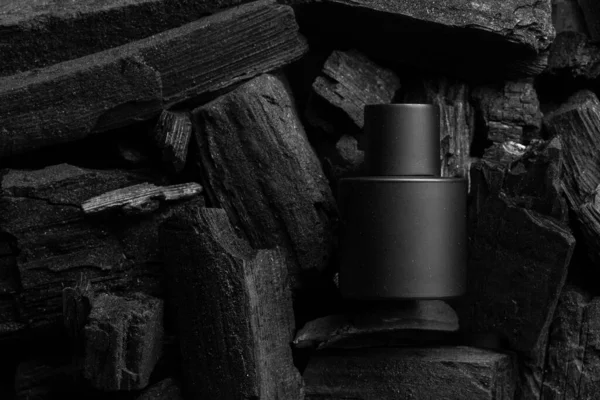 Kozmetik kavanozu krem, şampuan ve serumla süsle. Arkaplanı siyah kömür. Siyah dizayn.