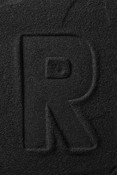 Impresión de una carta exprimida sobre arena negra . —  Fotos de Stock
