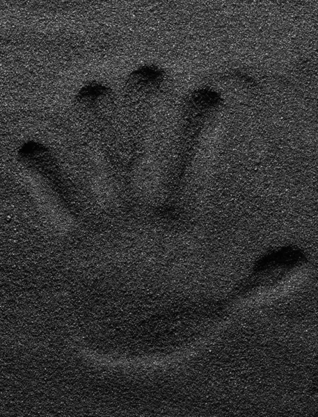 검은 화산암 모래에 손 자국 이 있습니다. 검정 색 디자인. 포스터. — 스톡 사진