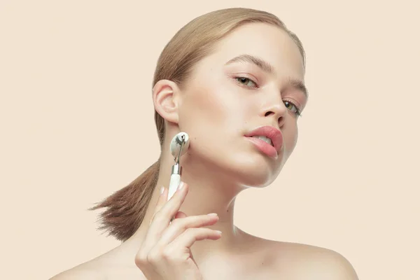 Mooi meisje maakt een gezichtsmassage gua sha jade kwarts roller, voor het effect van huidverjonging. Procedure thuis — Stockfoto