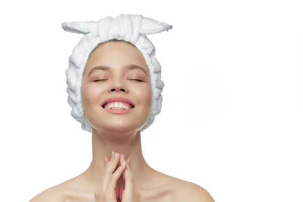 Uma jovem menina bonita em uma bandagem, sorrindo com os olhos fechados e ombros nus. Cartaz publicitário para cosméticos . — Fotografia de Stock
