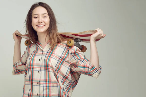 Cool girl estudiante en ropa casual aprende a montar un monopatín después de las clases en la Universidad . —  Fotos de Stock