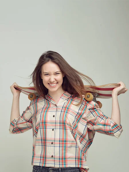 Cool tjej student i casual kläder lär sig att rida en skateboard efter lektioner på universitetet. — Stockfoto