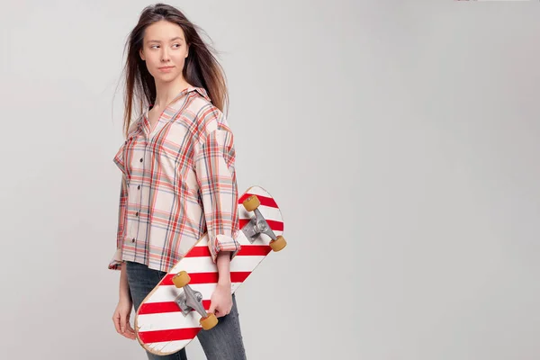 Cool girl estudiante en ropa casual aprende a montar un monopatín después de las clases en la Universidad . —  Fotos de Stock