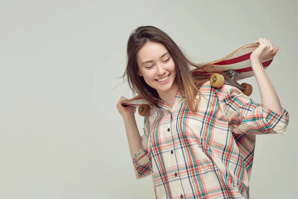 Cool girl estudiante en ropa casual aprende a montar un monopatín después de las clases en la Universidad . —  Fotos de Stock