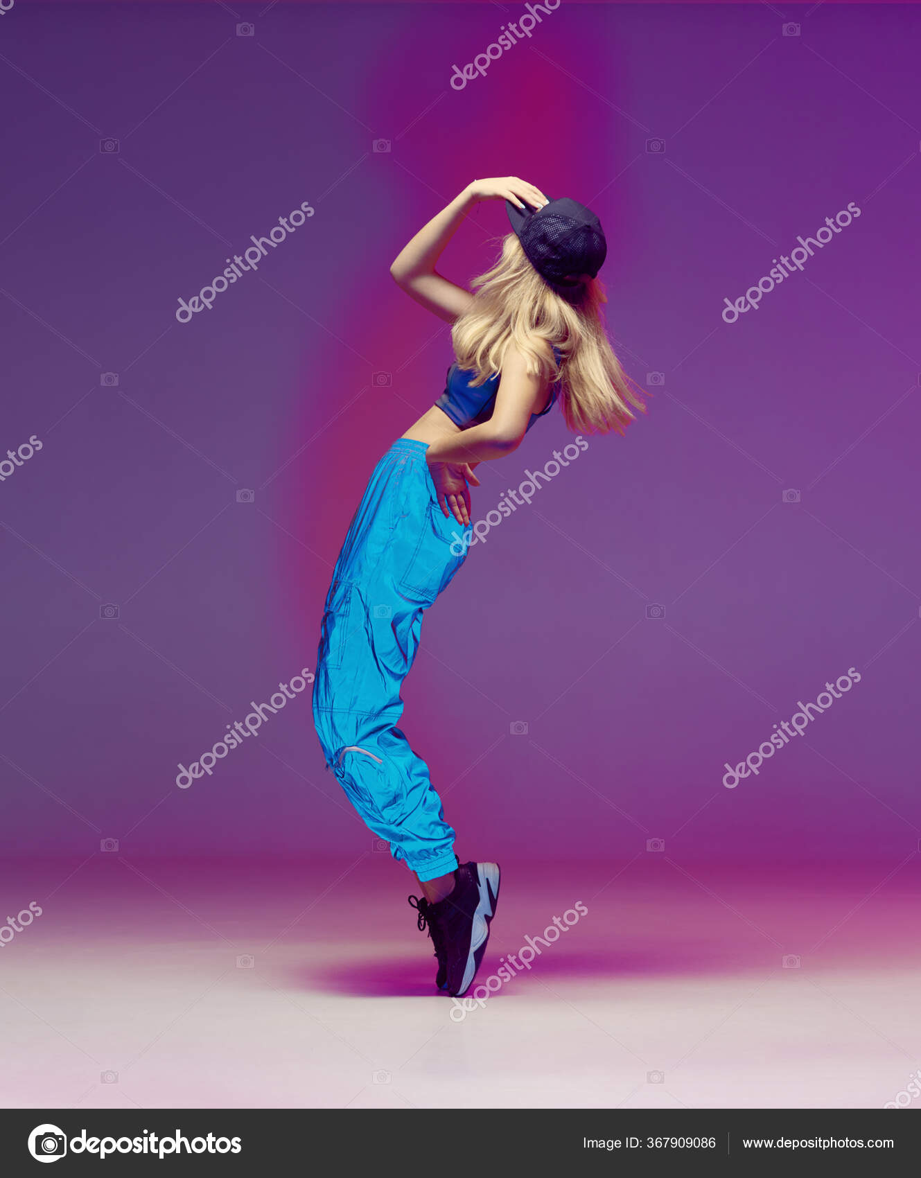 Cute teen girl dancing hip hop in reflective pants, baseball cap, in a  Studio with neon lighting. Dance color poster. Stock Photo by ©georgeeb22  367909086