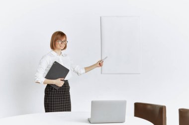 Şirin bir genç kız öğretmen, öğrencileri için internet ve dizüstü bilgisayar kullanarak uzaktan bir video dersi veriyor..