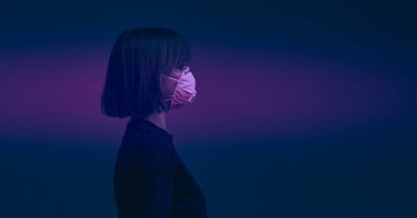 Dramatik bir geçmişi olan, cerrahi maske takmış genç bir kızın portresi. Virüs posterini durdur..