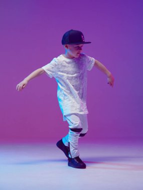 Stüdyoda neon ışıklarının arkasında hip hop dansı yapan havalı bir çocuk. Break dans posteri.