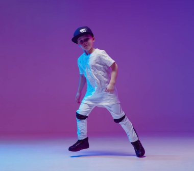 Stüdyoda neon ışıklarının arkasında hip hop dansı yapan havalı bir çocuk. Break dans posteri.