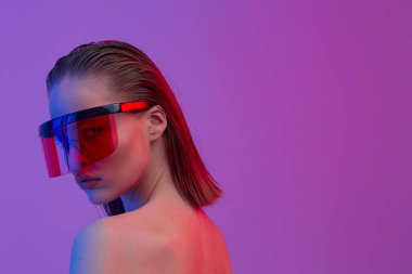 Şık bir saç stili ve parlak bir arka planda büyük cam pozlar veren şık gözlüklü havalı bir kız..