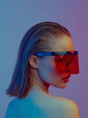 Şık bir saç stili ve parlak bir arka planda büyük cam pozlar veren şık gözlüklü havalı bir kız..