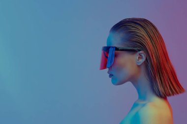 Şık bir saç stili ve parlak bir arka planda büyük cam pozlar veren şık gözlüklü havalı bir kız..