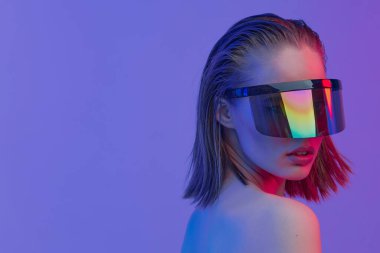 Şık bir saç stili ve parlak bir arka planda büyük cam pozlar veren şık gözlüklü havalı bir kız..