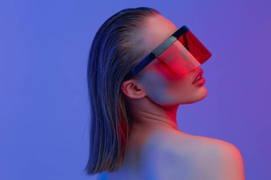 Şık bir saç stili ve parlak bir arka planda büyük cam pozlar veren şık gözlüklü havalı bir kız..