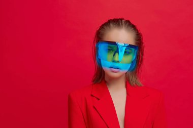 Havalı bir stil kızı, şık bir saç stili ve parlak kırmızı arka planda büyük cam pozlar veren şık gözlükleri var.