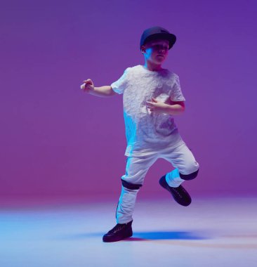 Stüdyoda neon ışıklarının arkasında hip hop dansı yapan havalı bir çocuk. Break dans posteri.