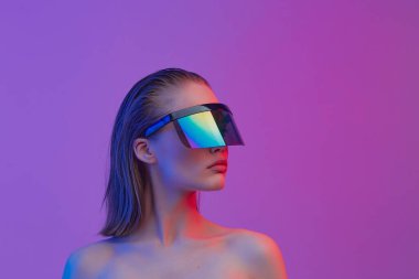 Şık bir saç stili ve parlak bir arka planda büyük cam pozlar veren şık gözlüklü havalı bir kız..