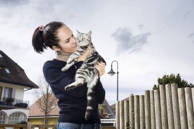 Genç kadın bir kedi ile poz 