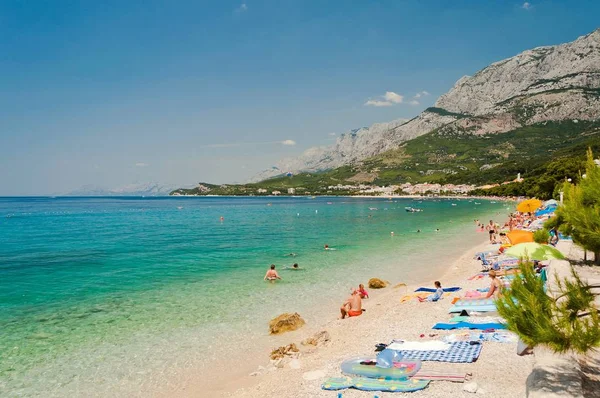 Splendida spiaggia con persone a Tucepi, Croazia Foto Stock Royalty Free