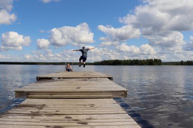 Ranua, Laponya, Finlandiya 'da Ranuanjarvi Gölü' ne atlayan çocuk. 