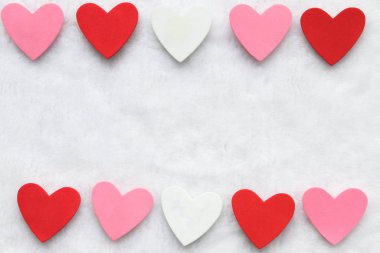 Üst ve alt satırda pembe, kırmızı ve beyaz kalpler beyaz arkaplan üzerinde metin için boşluk. 