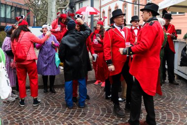 İzleyiciler Mainz, Almanya 'daki Gül Pazartesi geçit töreninde parlak kırmızı kostümler giyiyorlar.
